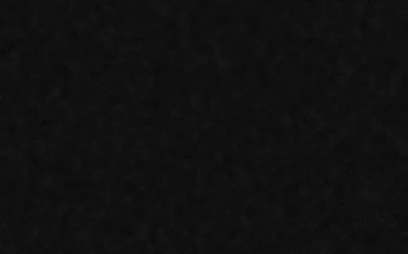 A flat black wall behind the bed, empty and unlit
